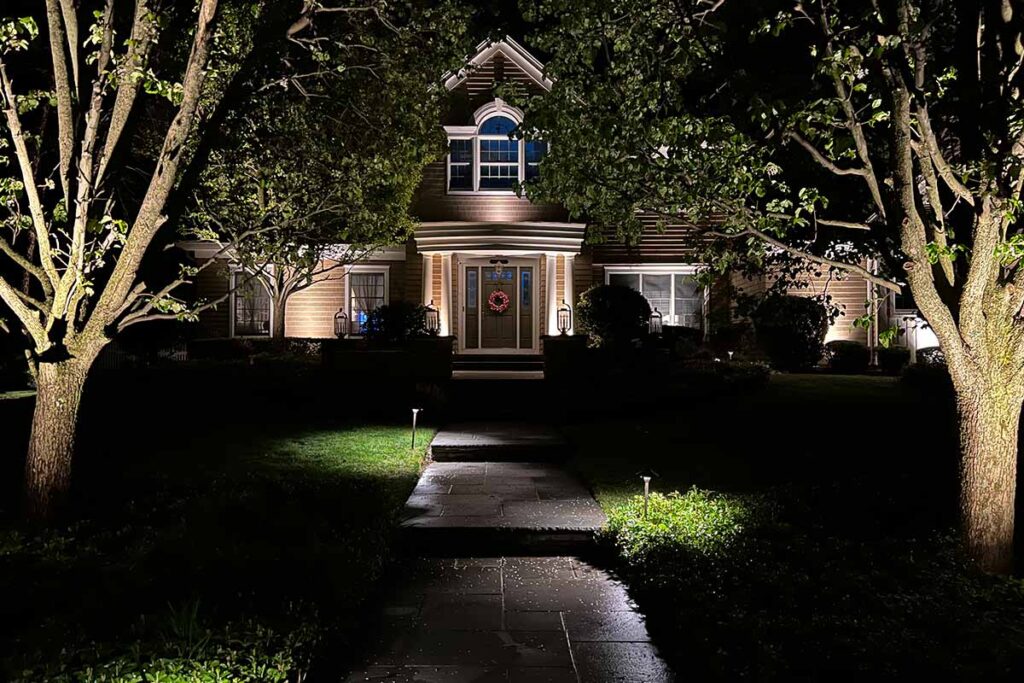 Inviting home exterior illuminated by outdoor lighting at night.
