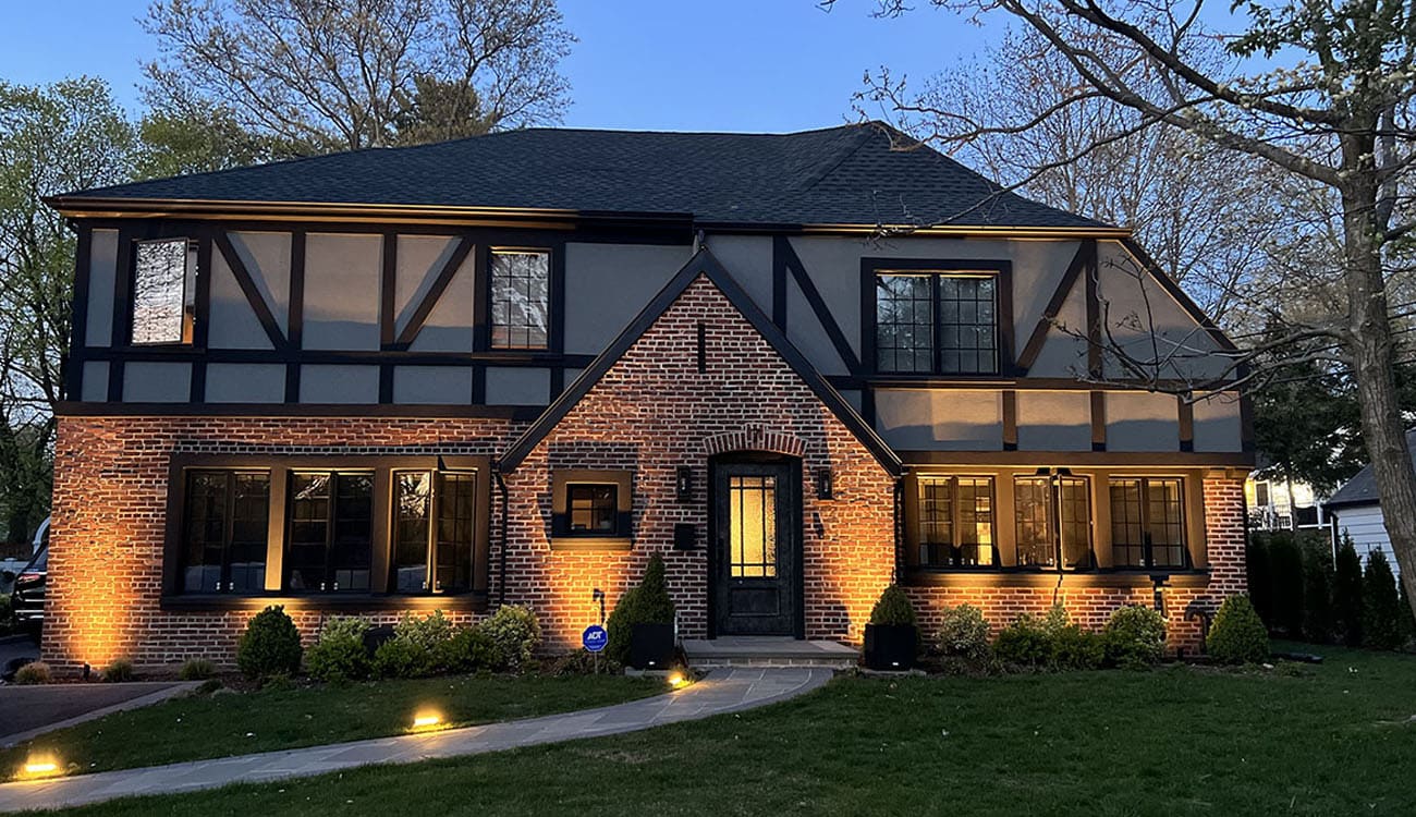 Brick home with pathway and facade lighting showcasing the results of expert lighting system maintenance for balanced illumination and safety.
