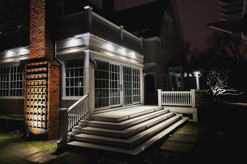 Luxury home exterior showcasing professional downlighting installation that brightens steps, walls, and architectural details at night.