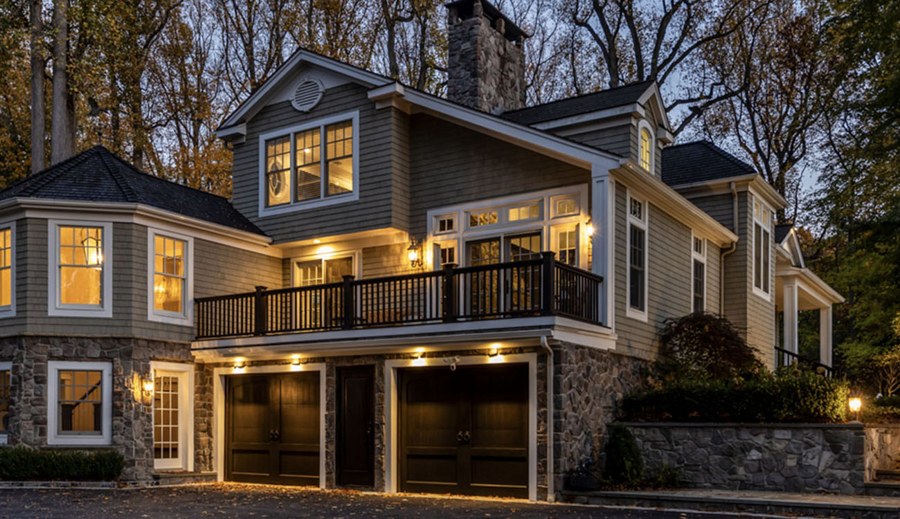 Modern home exterior featuring warm architectural lighting in Norfolk County that highlights design details and structure.