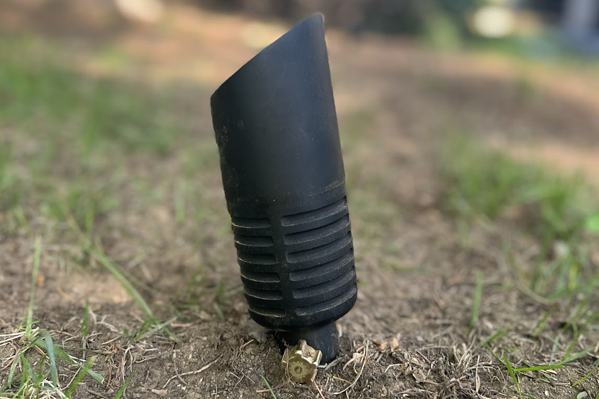 Blog 2 A ground spotlight leans in the soil, showing why Outdoor Lighting Inspection and Safety matters for keeping fixtures stable and working properly.